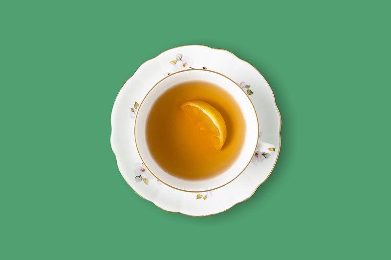 a cup of tea from top angle on a green background