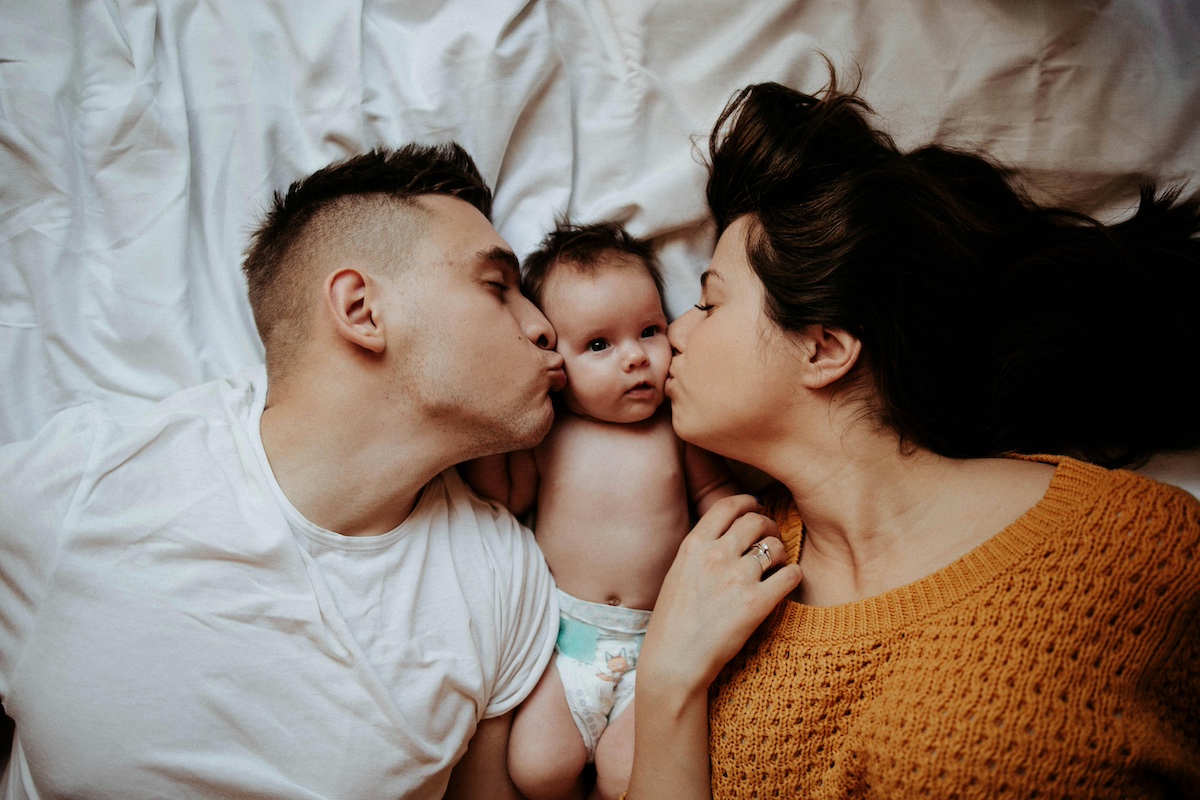 Parents kissing newborn