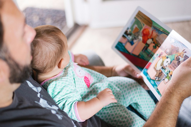 parent and a kid sitting and reading a book