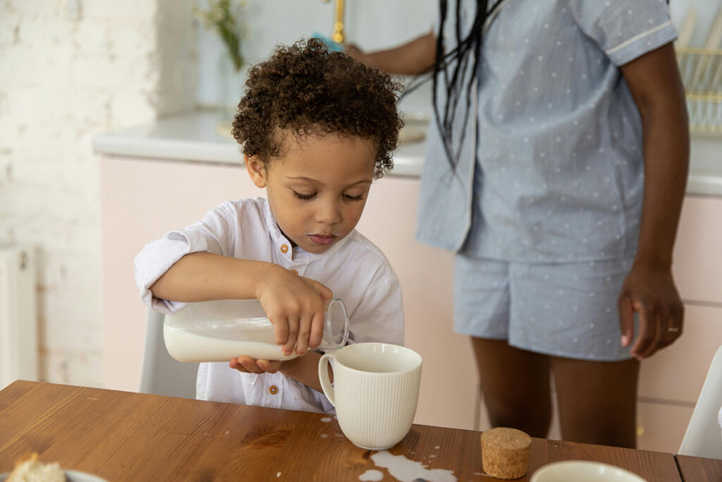 kid is pouring milk in glass