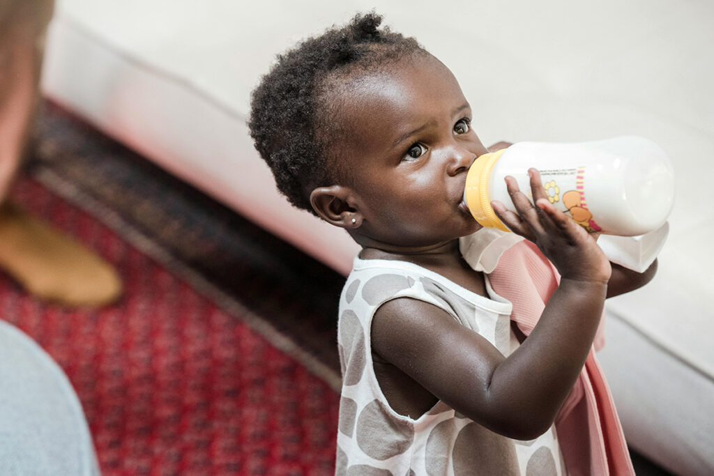 A baby drinking milk out of a bottle