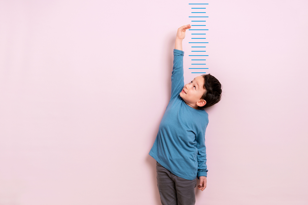 a child standing against a ruler to measure height