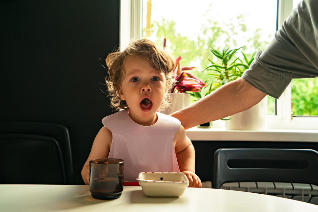 A person patting a choking baby's back.