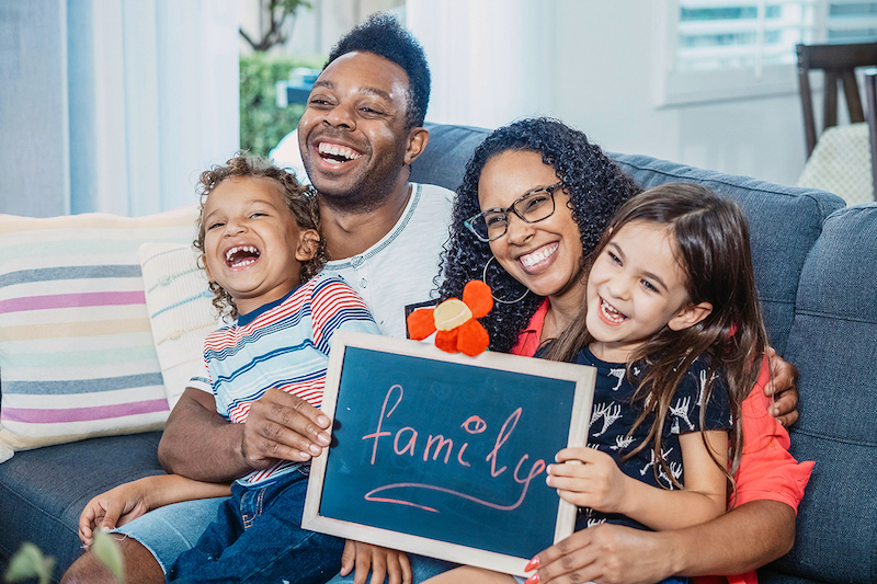 A family sitting on a couch laughing