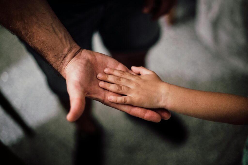 Child's hand placed on an adult hand