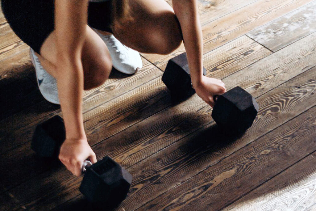 a person holding dumbell placing on the floor