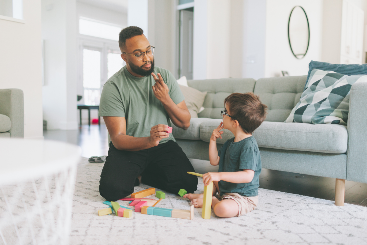 A person teaching a child sign language.