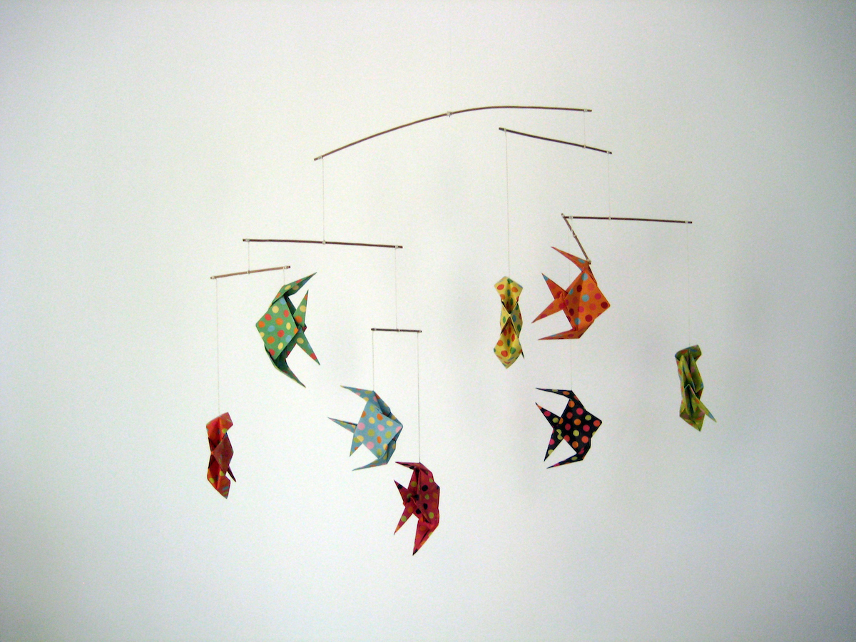 A mobile made of colorful origami fish on a white background.