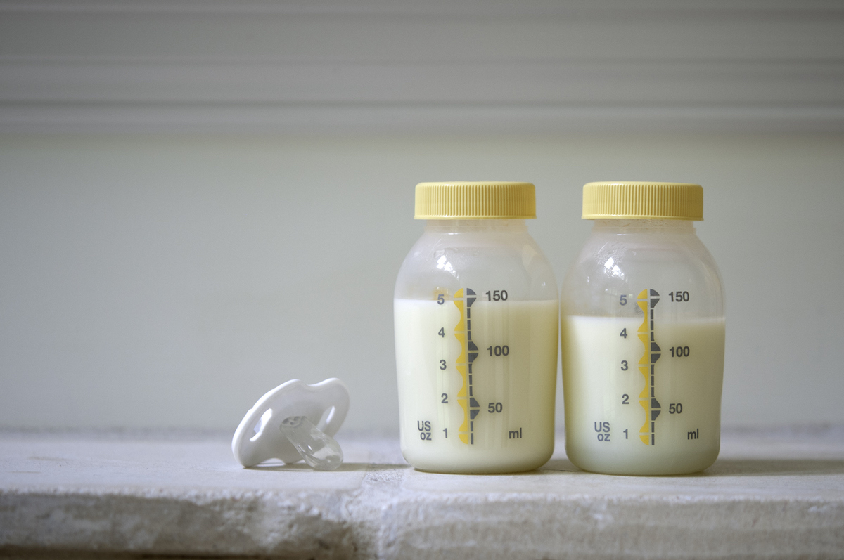 Two bottles of breastmilk on a kitchen counter.