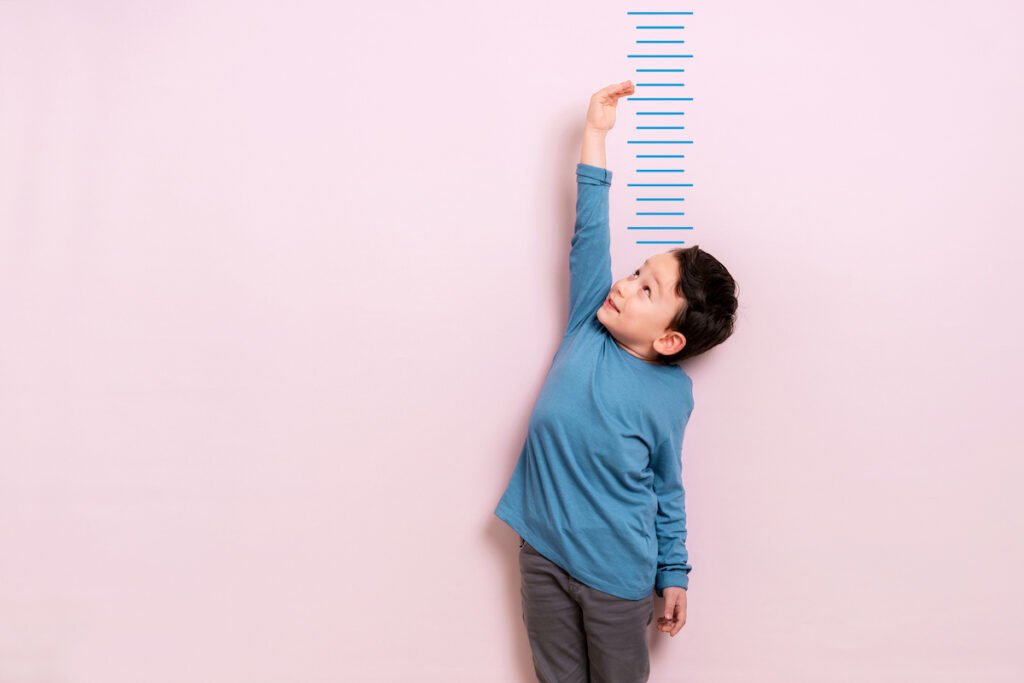 A child measuring their height on the wall.