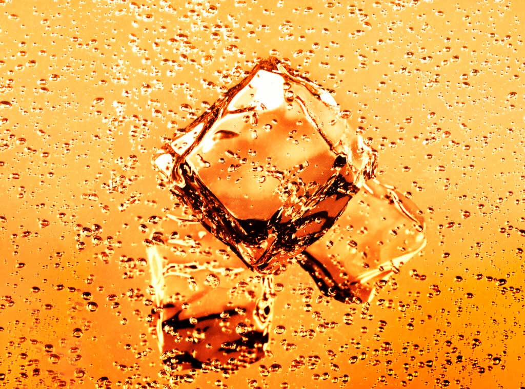 Close-up view of ice cubes floating in bubble soda.
