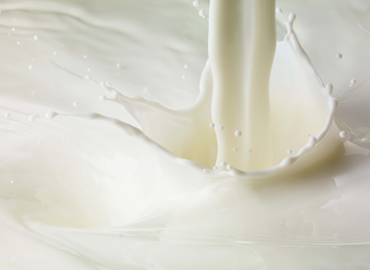 Close-up of milk being poured and splashing.