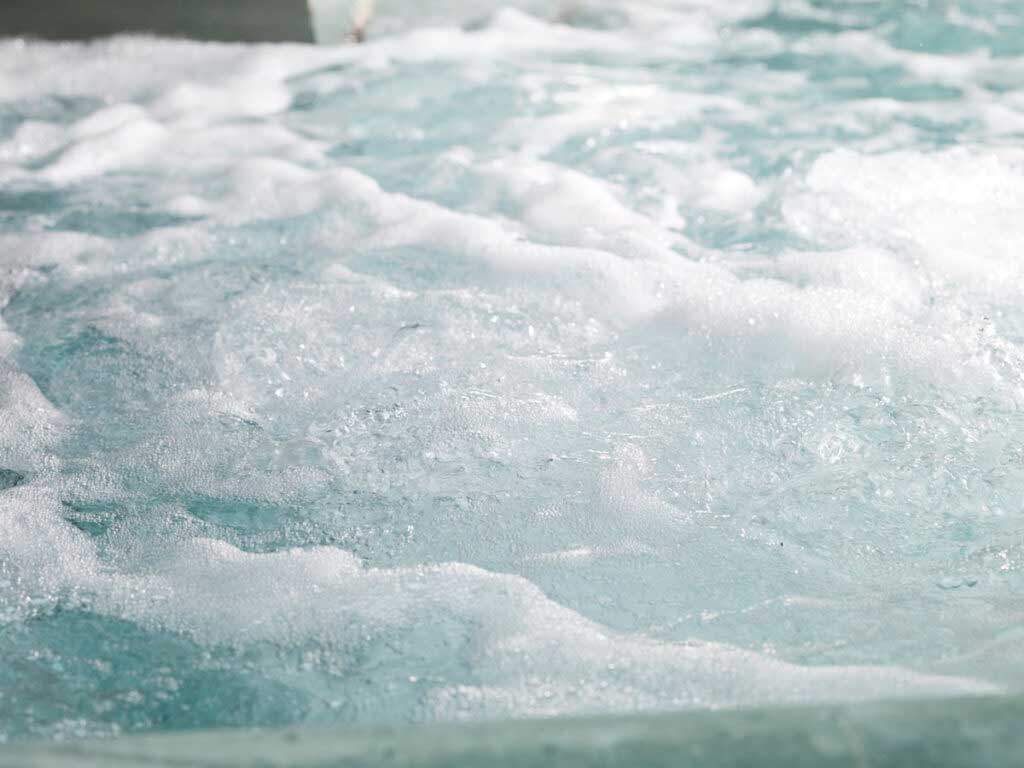 A close-up of foaming water in a hot tub.