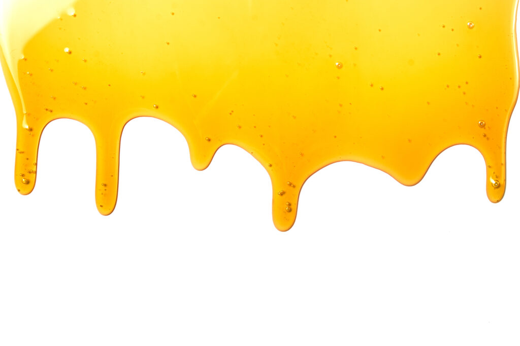 Sticky honey drips across a white background.