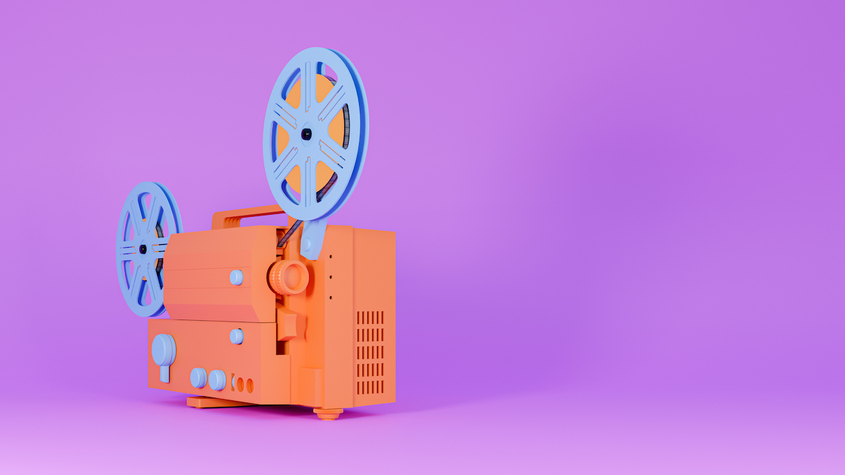 An orange and blue video projector is seen on a purple background.
