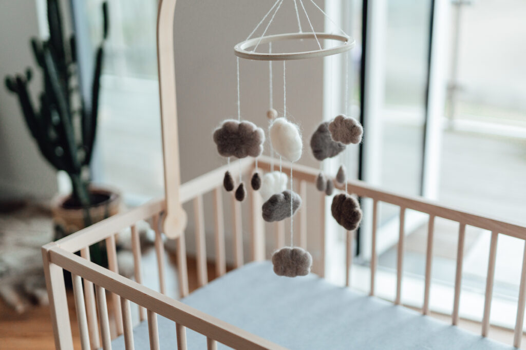 A crib with a raincloud mobile hung above it.