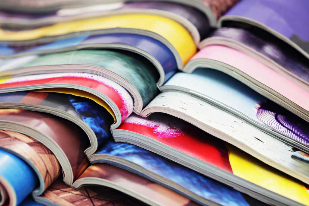 A stack of colorful magazines are seen close-up.