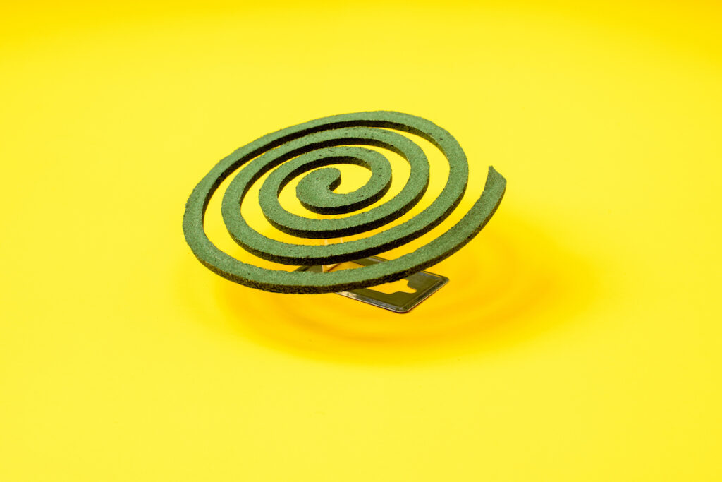 A green mosquito coil on a yellow background.