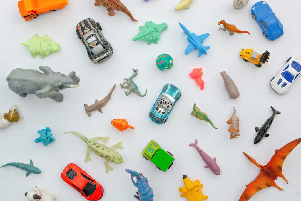 An array of small children's toys, including cars, dinosaurs, jets and more.