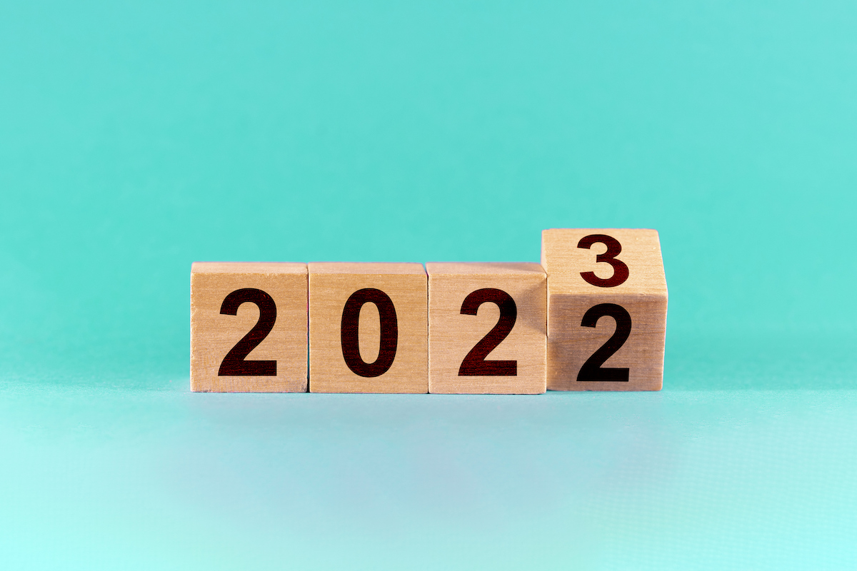 Wooden blocks on a teal background spell out 2022 and 2023.