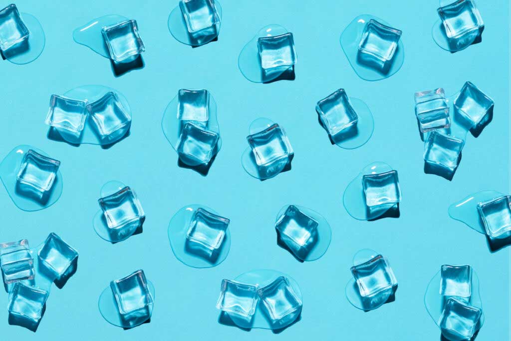 Slightly melting ice cubes scattered across a bright blue background.