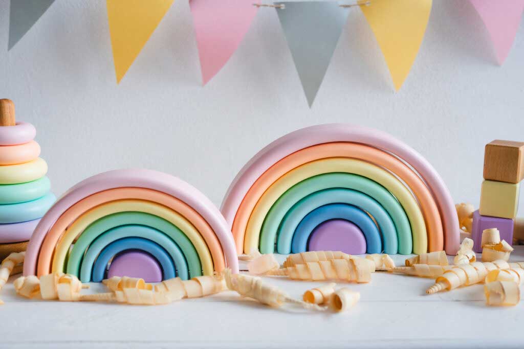 Wooden rainbow toys on a gray background.