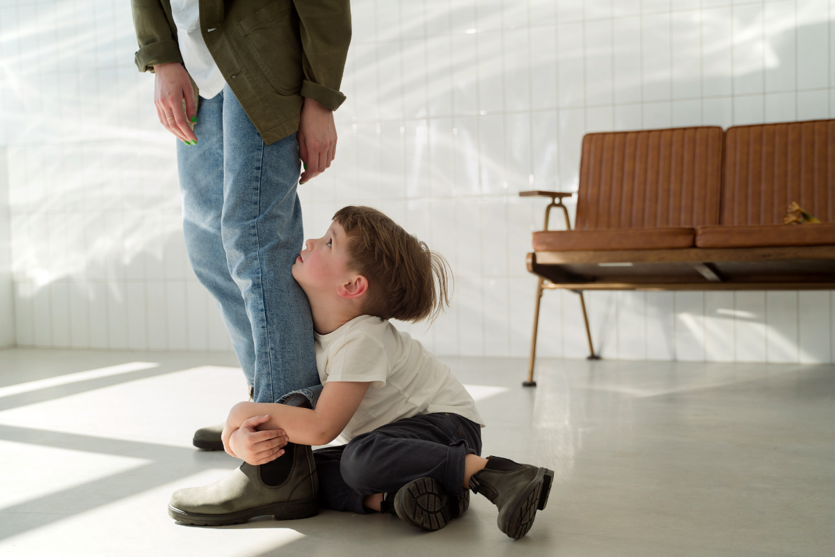 A kid holding the legs of a parent