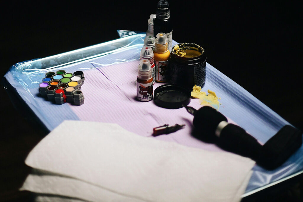 a tattoo pen and dye colors on a table