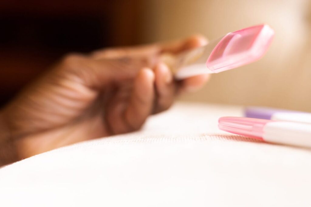Close-up of a hand holding a pregnancy test.