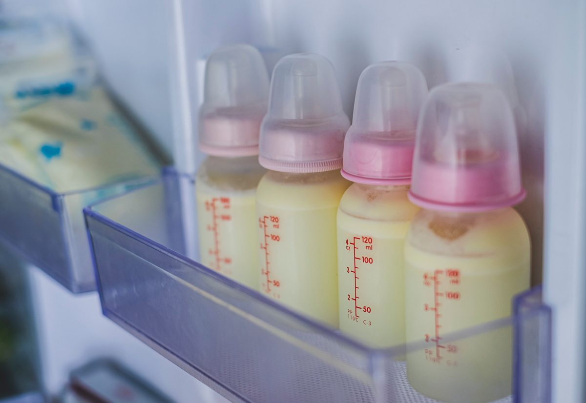 A freezer door shows bags and bottles of frozen breastmilk.