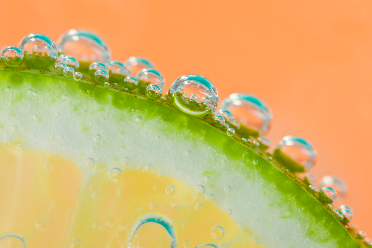 A close-up of a lime in a fizzing seltzer drink.
