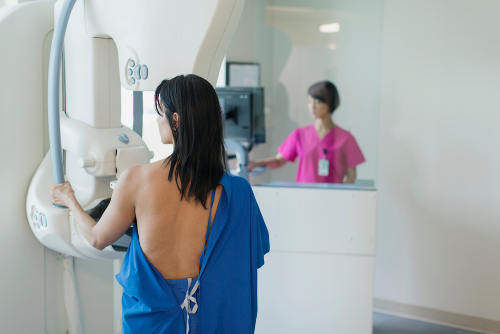 A patient looks out a window while getting an annual mammogram at a hospital.