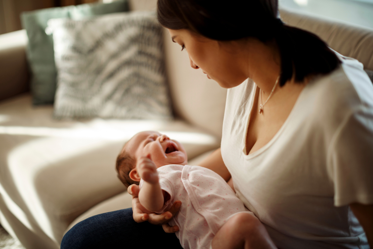 A parent holding a crying baby