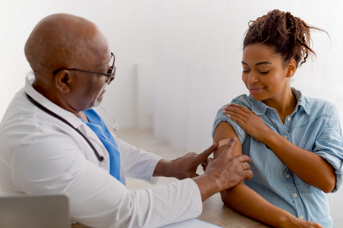 Pregnant woman receiving vaccine shot from doctor