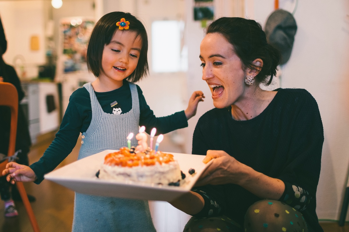 Parent gives child a birthday cake