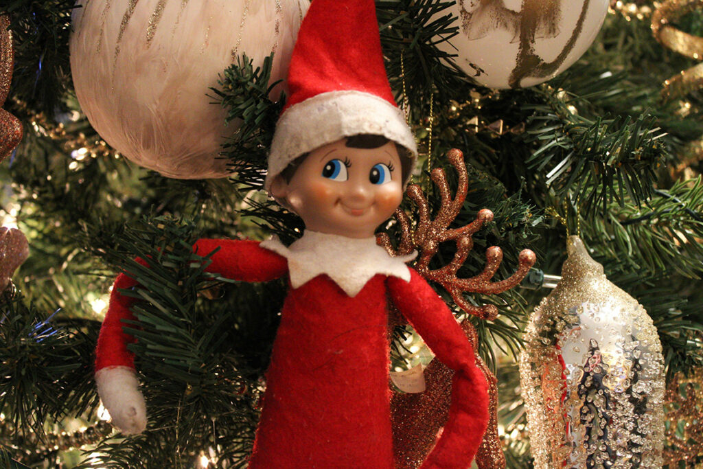 An elf sitting on a christmas tree