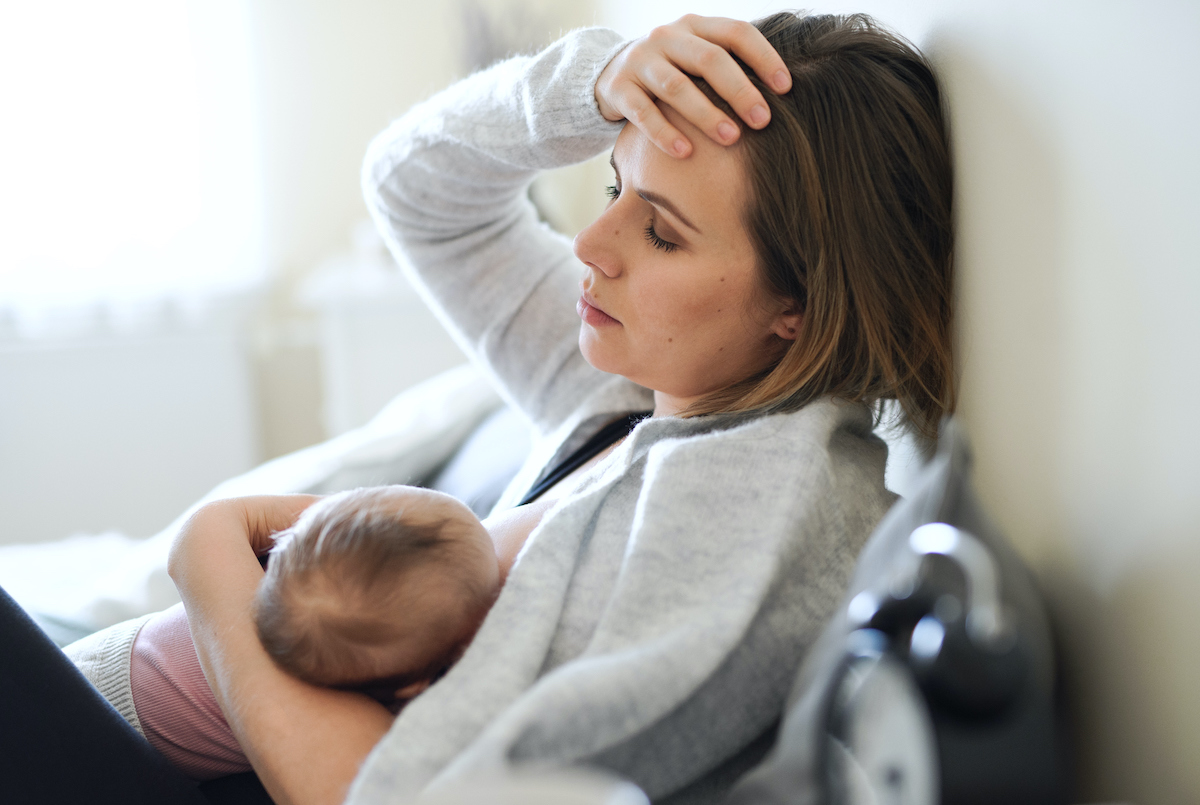 Woman looks worried while breastfeeding