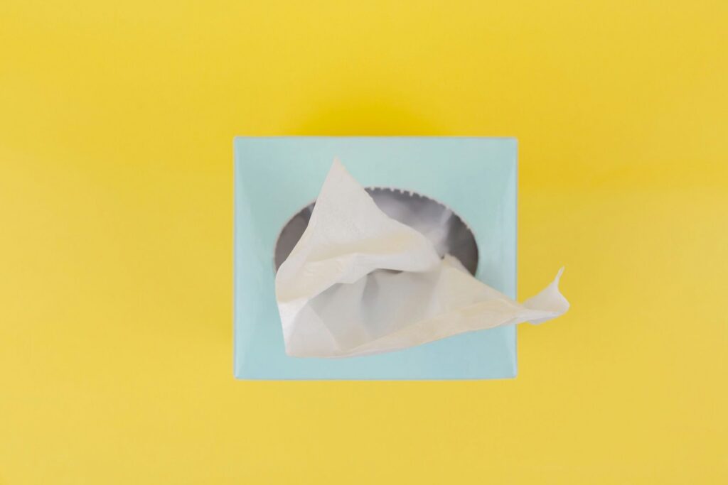 A light blue box of tissues is seen on a bright yellow background.