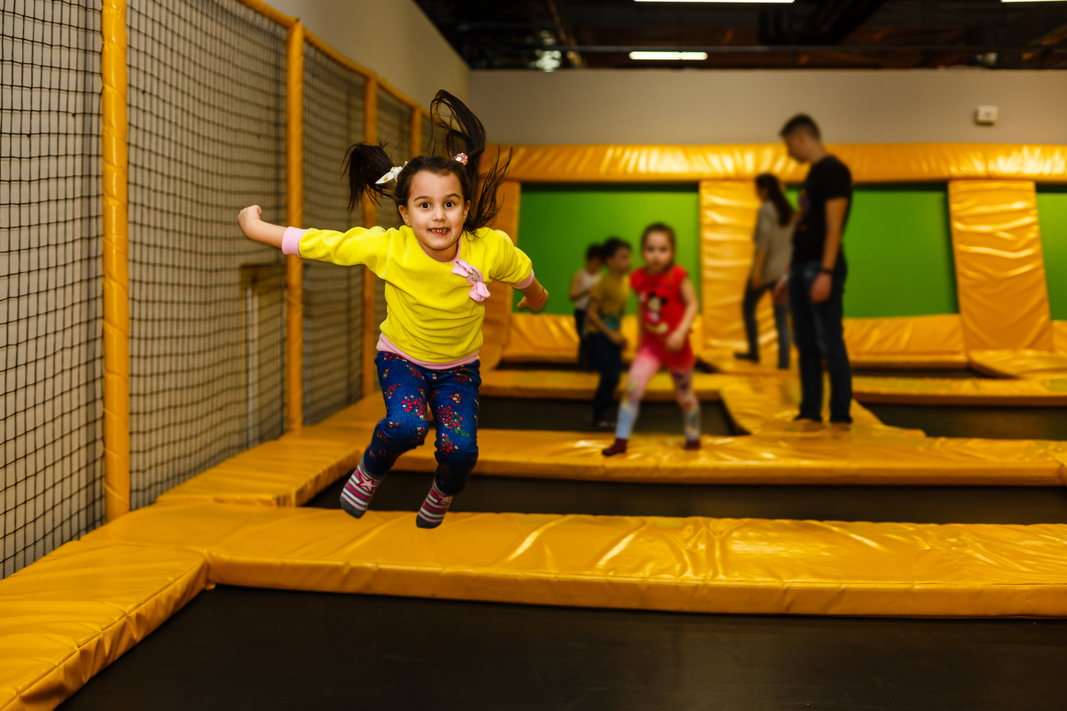 Kids jumping in an indoor trampoline park.