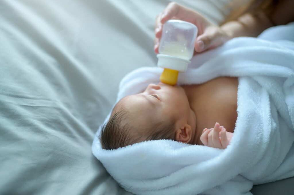 A tiny baby drinks from a bottle.