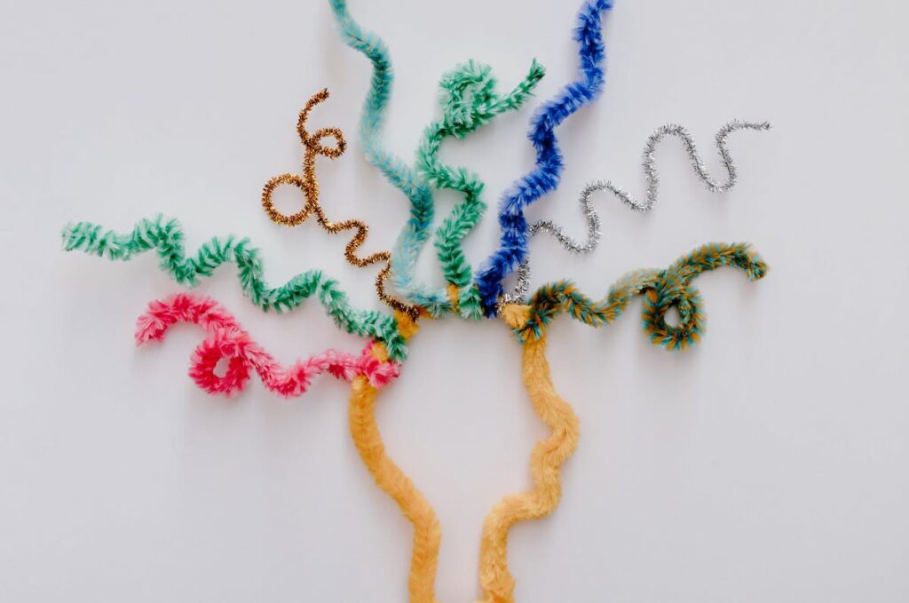 Curly pipe cleaners spring out of a pipe-cleaner head to illustration cognitive chaos.