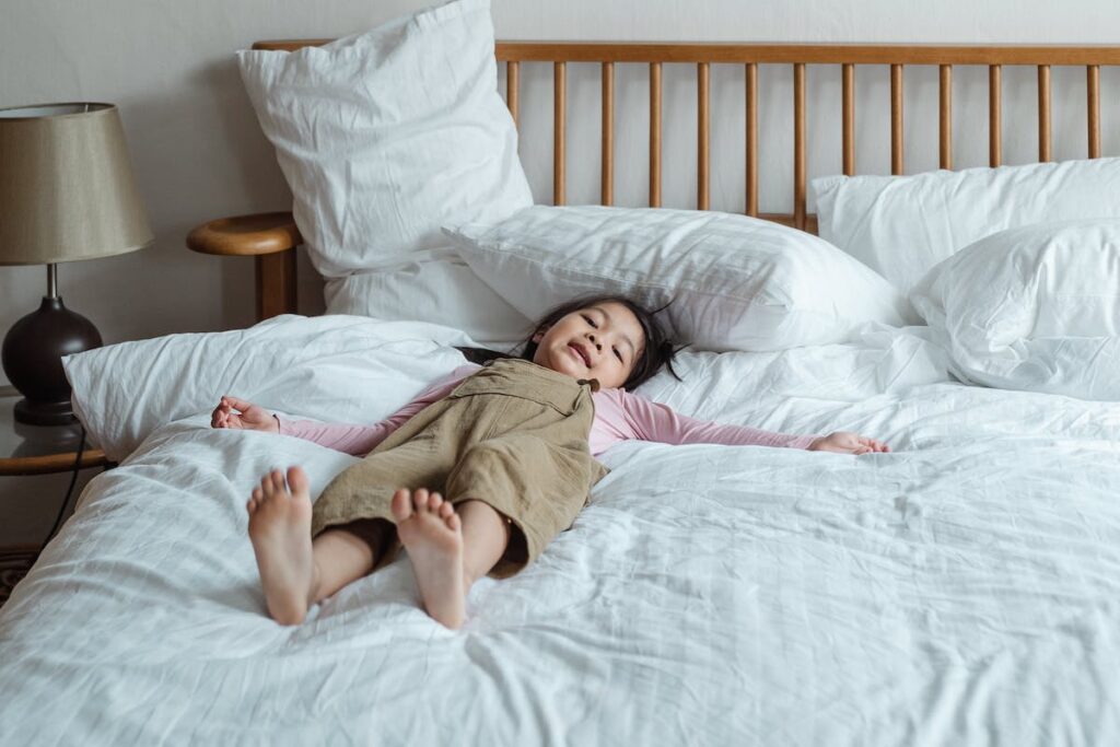A child sprawls across a bed.