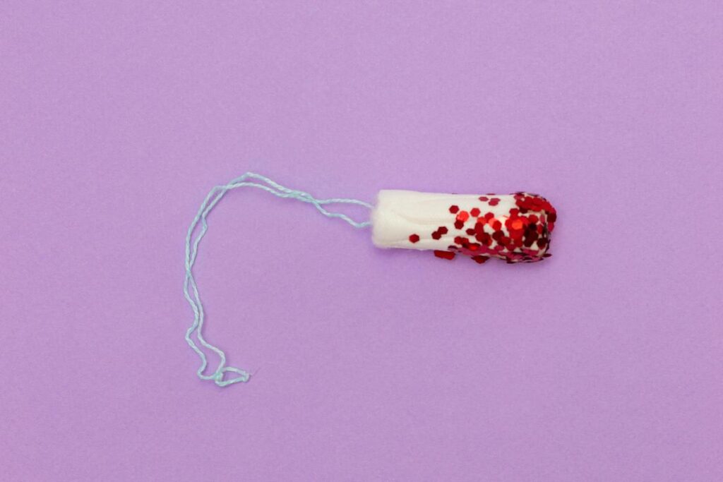 Tampon with glitter on purple background
