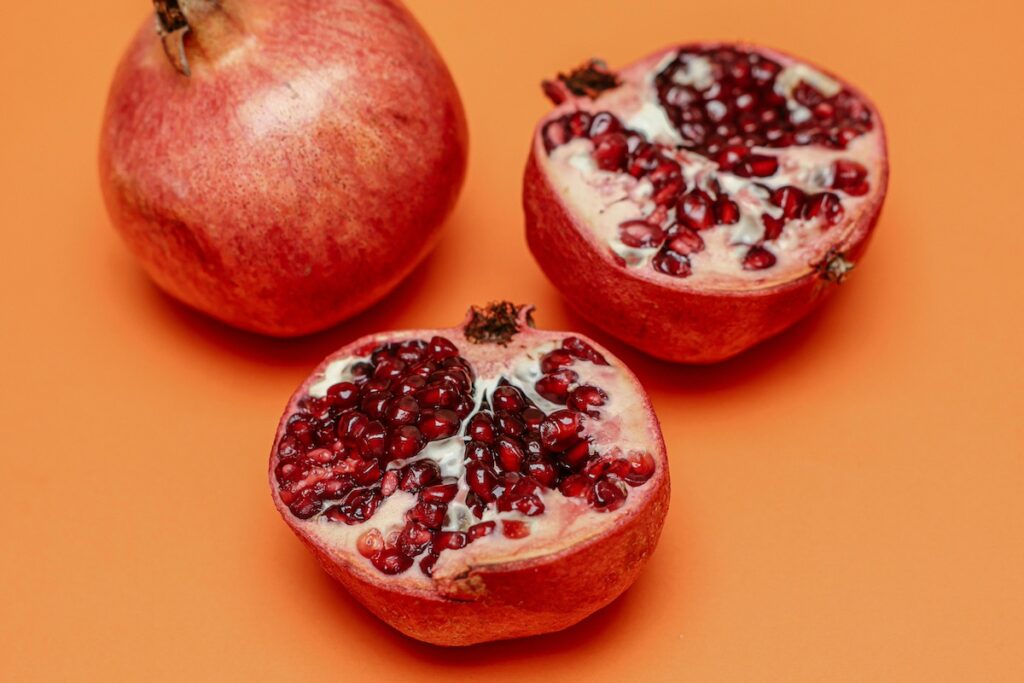 Halved pomegranate on orange background
