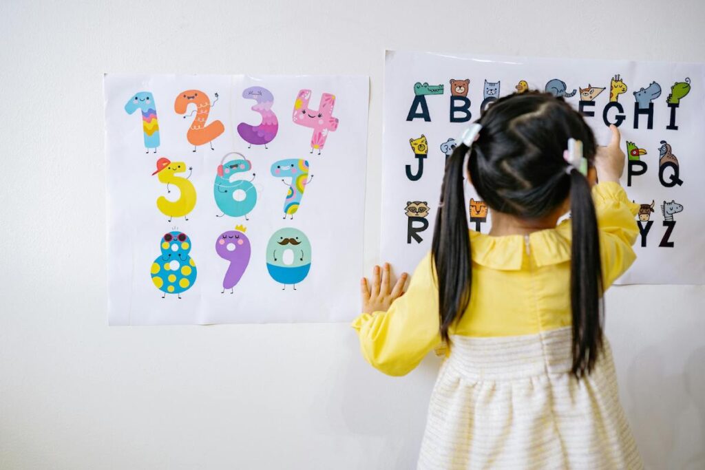 Child looks at letters on wall