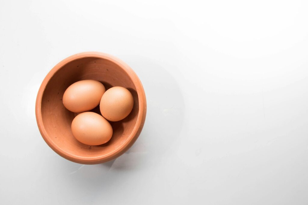 Eggs in a bowl on white background.