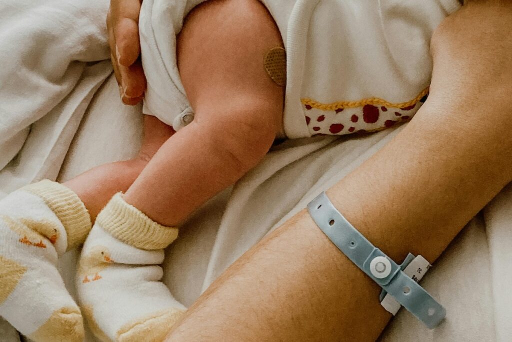 New baby leg and parent arm with hospital bracelet