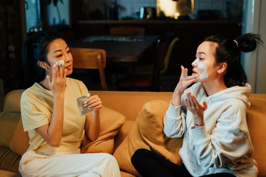 Two people putting on skincare masks