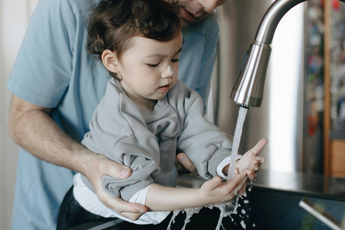 baby hand washing with parent