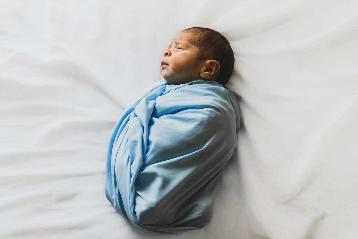A baby sleeping in a weighed sleep sack.